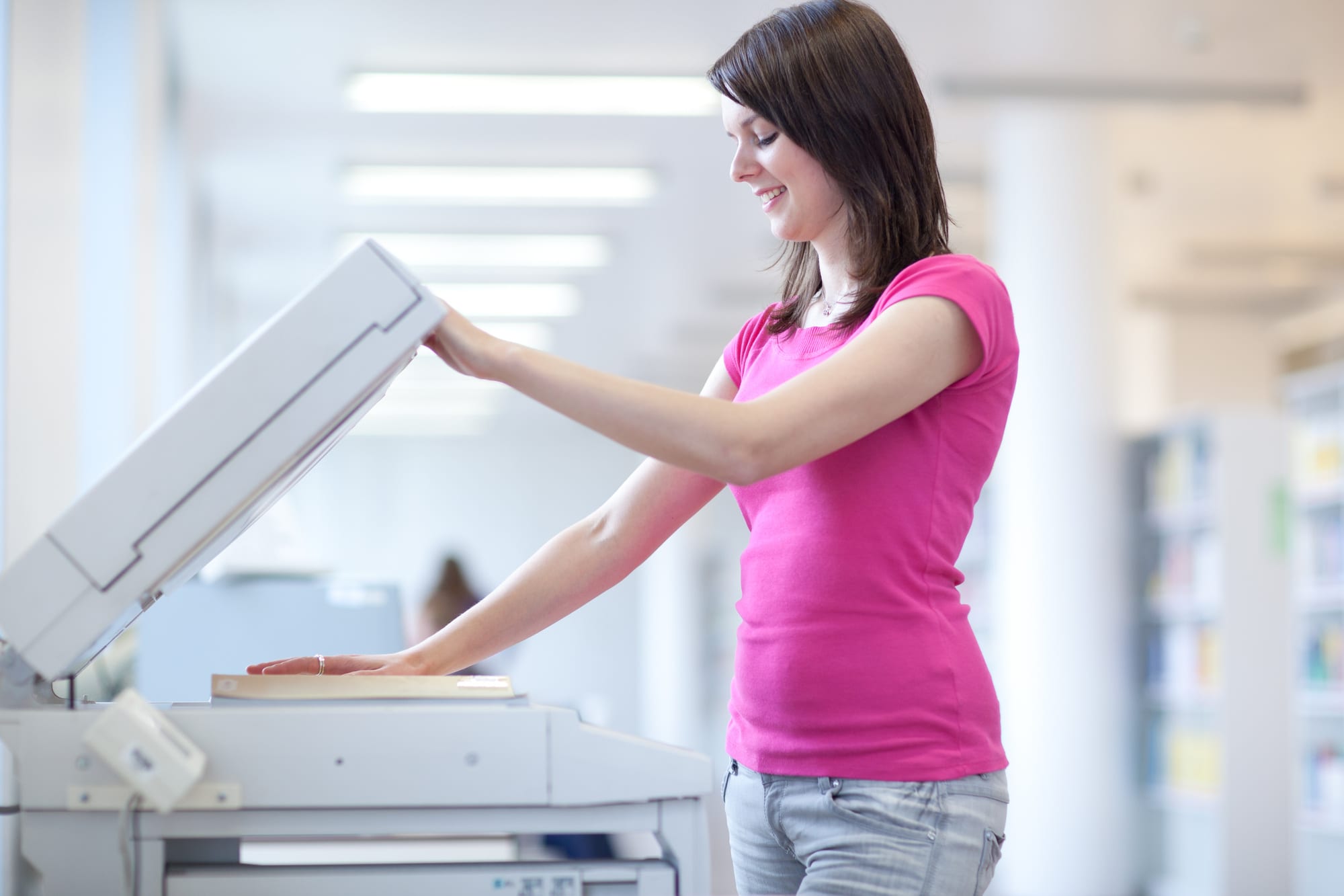 pretty young woman using a copy machine (shallow DOF; color tone